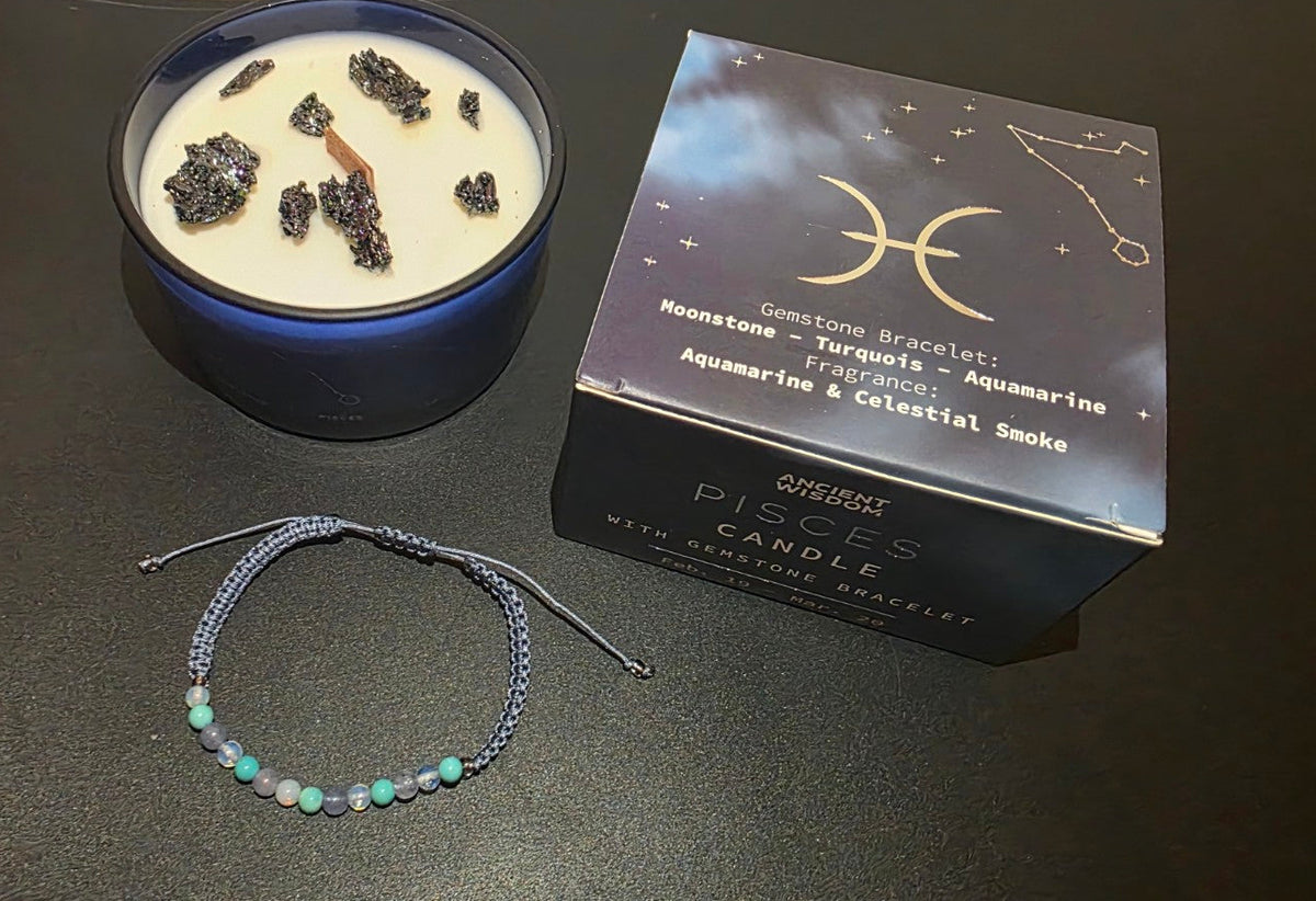 Pisces zodiac candle with gemstone bracelet and gift box shown from an angle